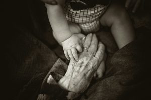 child's hand holding old hand